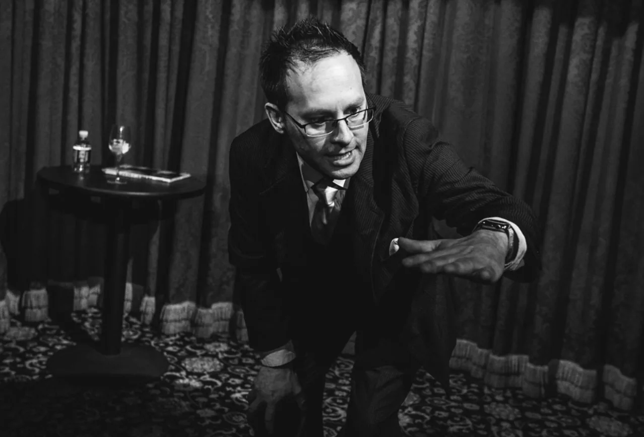 Paul Vigil leaning in to perform a close-up effect in black and white